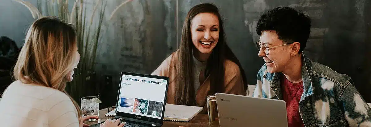 Studierende am Tisch bei einer Gruppenarbeit am Laptop