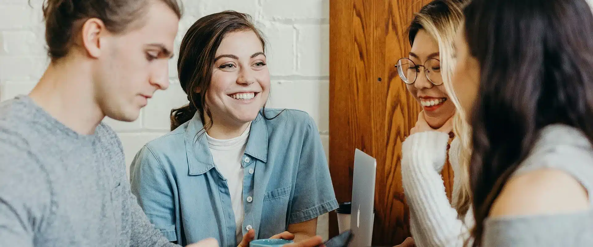 Students talk at a table in the common room